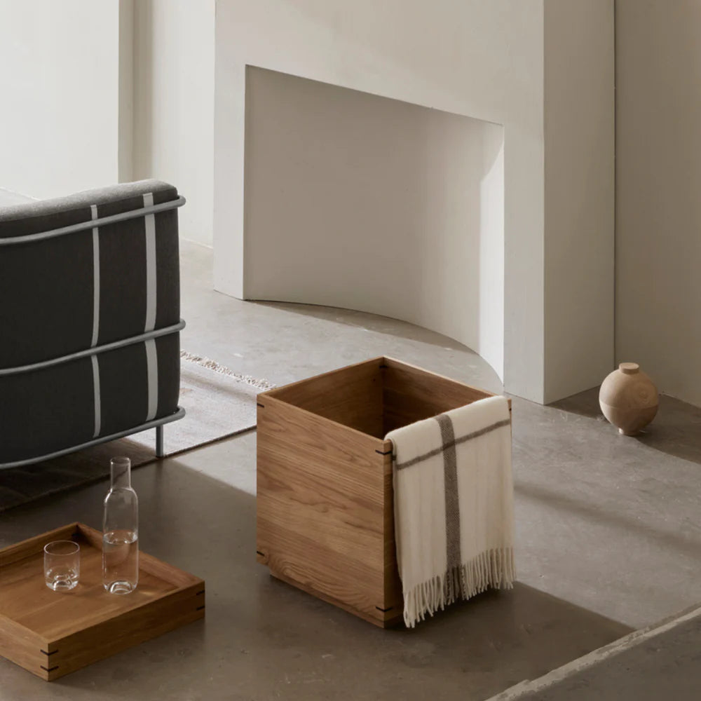 A living room with a Japanese Tray Table by Kristina Dam Studio and a wooden box, showcasing the Scandinavian interpretation by Kristina Dam Studio.