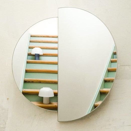 An innovative RAE MIRROR by MAZO featuring a mirror on a wall with stairs.