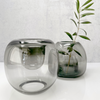 Two BÜBLE DIFFUSERs from HOUSE OF GOOD with a plant in them, perfect for adding a touch of nature to your space.