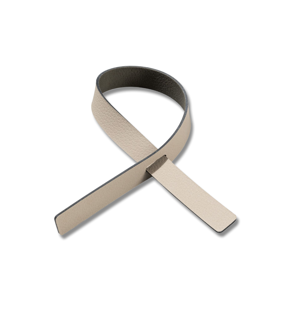 A beige ribbon adorns a white background, reminiscent of Napkin Loop (Set of 4) by LIND DNA on a dinner table.