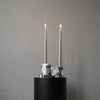 Brick candle holders from 101 Copenhagen placed on a solid marble pedestal.