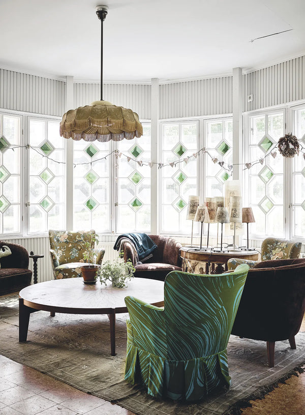 A living room with large windows and green chairs from HAPPY HOMES CREATIVE by COZY.