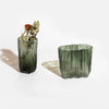 Two MELT vases with a green hue on a white surface by Antrei Hartikainen.