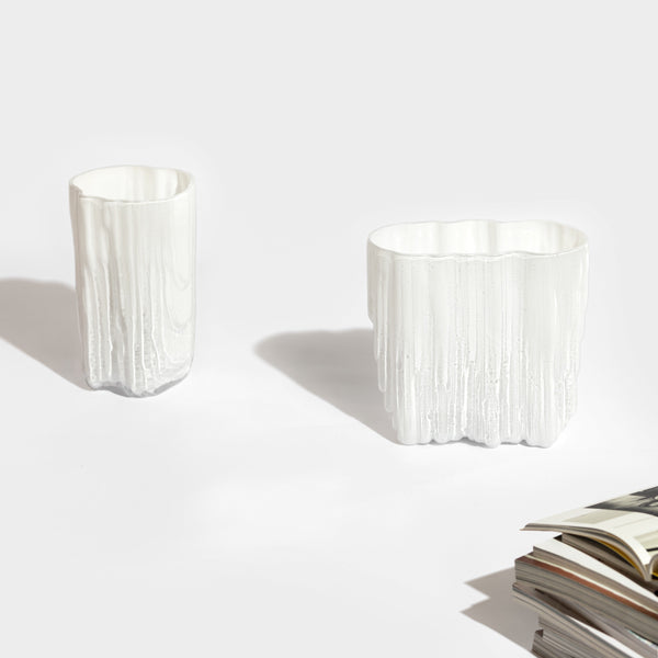 Two MELT VASE vases by ANTREI HARTIKAINEN on a table next to a book.