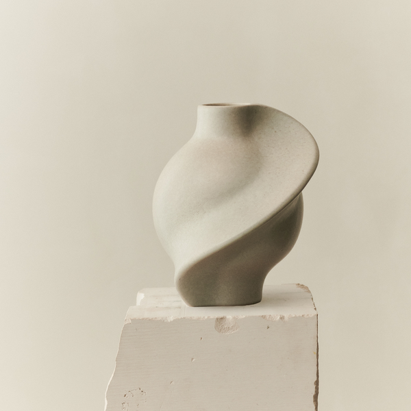An LOUISE ROE PIROUT VASE VINTAGE GLAZE resting on top of a block of concrete.