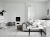A white living room with HAPPY HOMES WHITE WALLS and wooden floors, furnished with COZY white furniture.