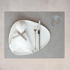 A white plate with a knife and fork on it featuring an OEKO-TEX® recycled leather SQUARE DINNER MAT by LIND DNA.