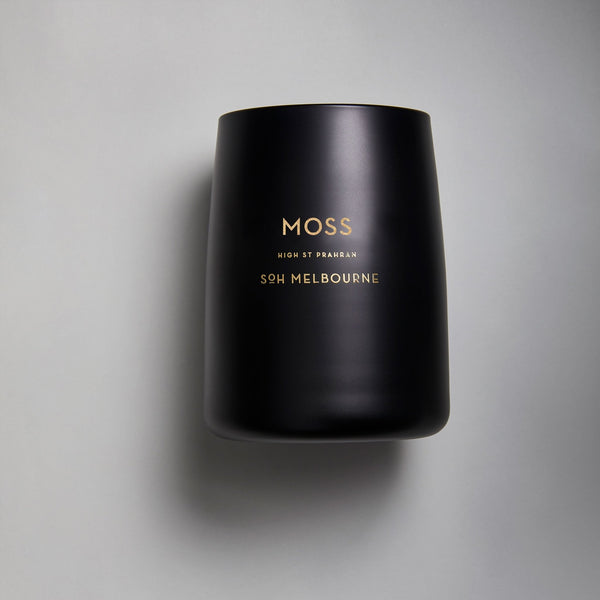 A black SOH MELBOURNE candle with the words MOSS CANDLE on it.