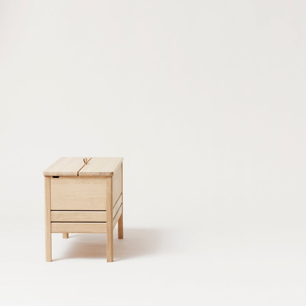 A FORM & REFINE LINE STORAGE BENCH 68 sitting on a white surface.