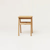 A small FORM & REFINE Gestalt Haus wooden side table on a white background.