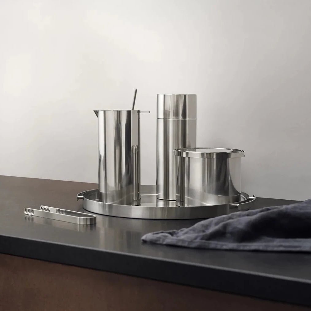 A set of STELTON pots and pans on a black countertop.