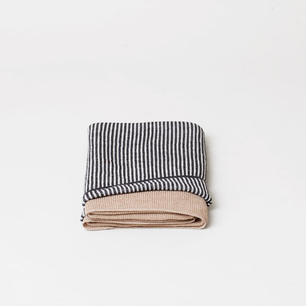 An AYMARA PLAID THROWS folded on top of a white surface at Gestalt Haus.