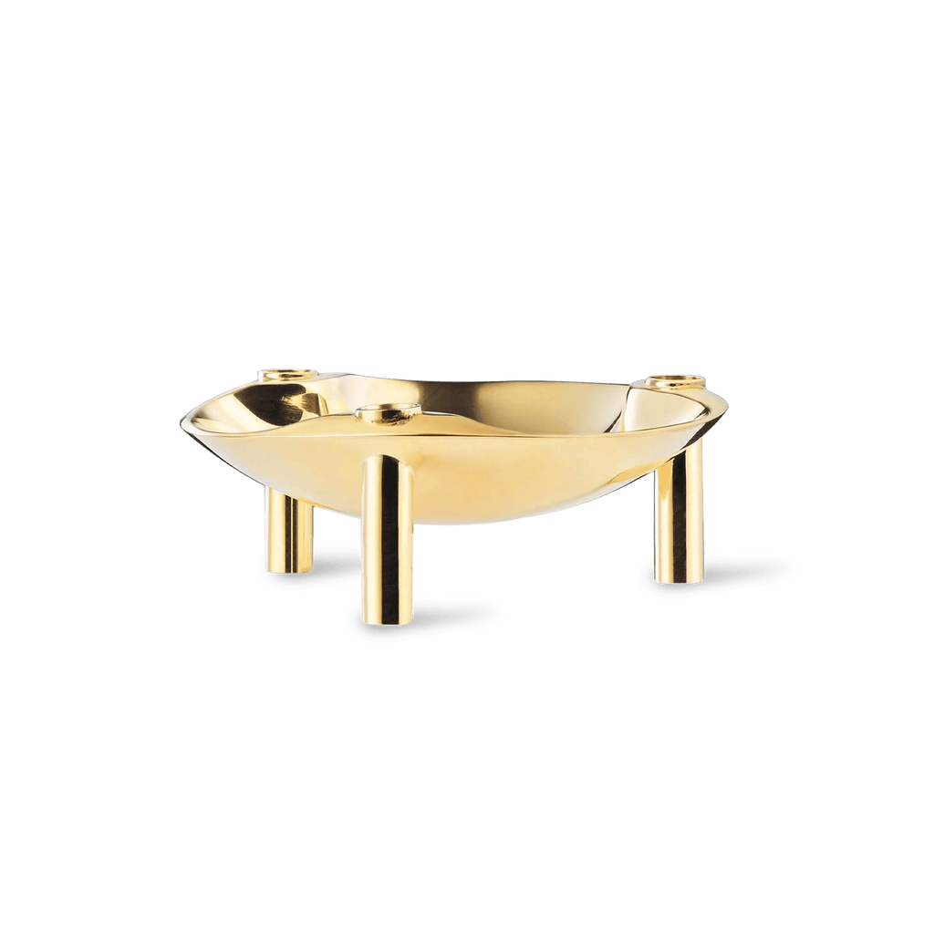 A gold bowl with two legs on a white background, reminiscent of Gestalt Haus.