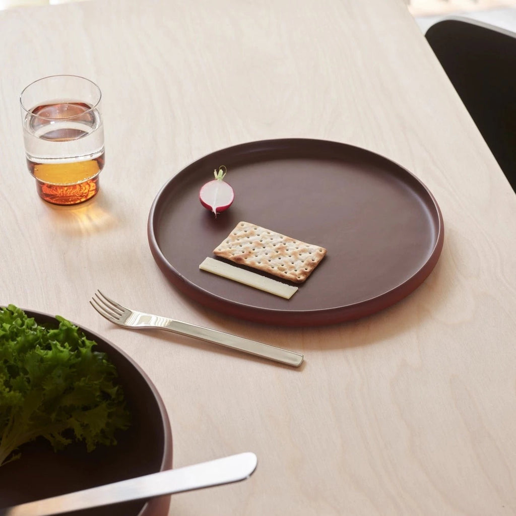AARON PROBYN's COLOMBO TABLEWARE plate showcases a cracker and glass of water, exuding the essence of Gestalt Haus.