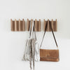 A COLUMN COAT RACK by KRISTINA DAM STUDIO with a bag hanging on it at Gestalt Haus.