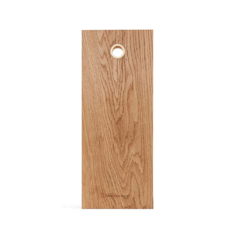 A DRY STUDIOS OAK CUTTING BOARD with a hole in the middle, made by FRAMA.