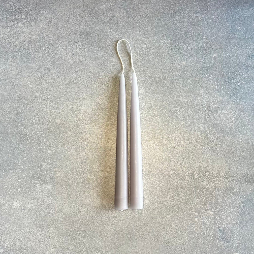A pair of DANICA DESIGNS HAND-DIPPED TAPER CANDLES on a Gestalt Haus surface.