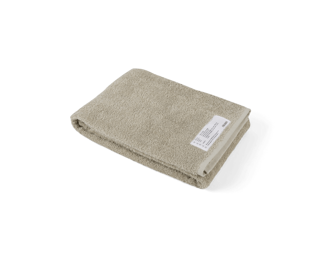 A beige Heavy Towel by FRAMA with a white background and Gestalt Haus.
