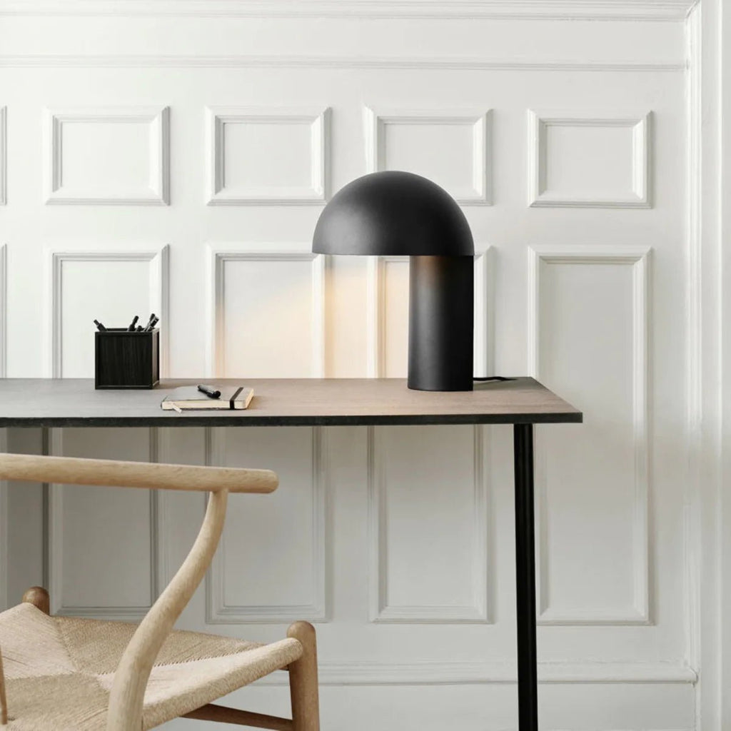 A desk with a GEJST LEERY TABLE LAMP and a chair in the Gestalt Haus style.