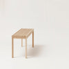 A lightweight bench with slats on a white background, inspired by the Gestalt Haus aesthetic.