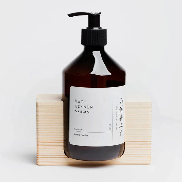 A bottle of Hetkinen Natural Hand Soap displayed on a wooden block at Gestalt Haus.
