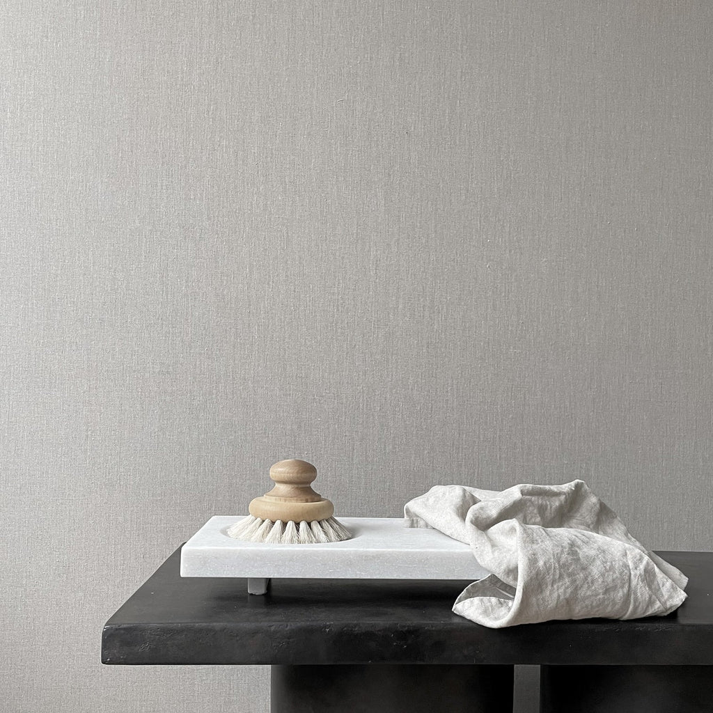 A table with an OKA Marble Tray and a brush on it, manufactured by 101 Copenhagen and available at Gestalt Haus.