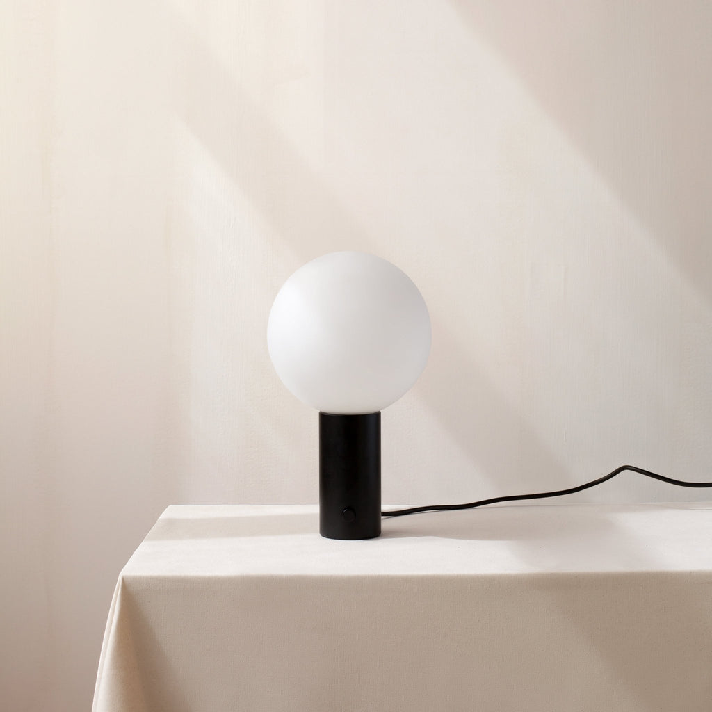 An ORB TABLE LAMP by IN COMMON WITH on a white Gestalt Haus table.