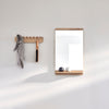 A FORM & REFINE RIM WALL MIRROR adorned with a towel hanging from its Gestalt Haus-inspired design.