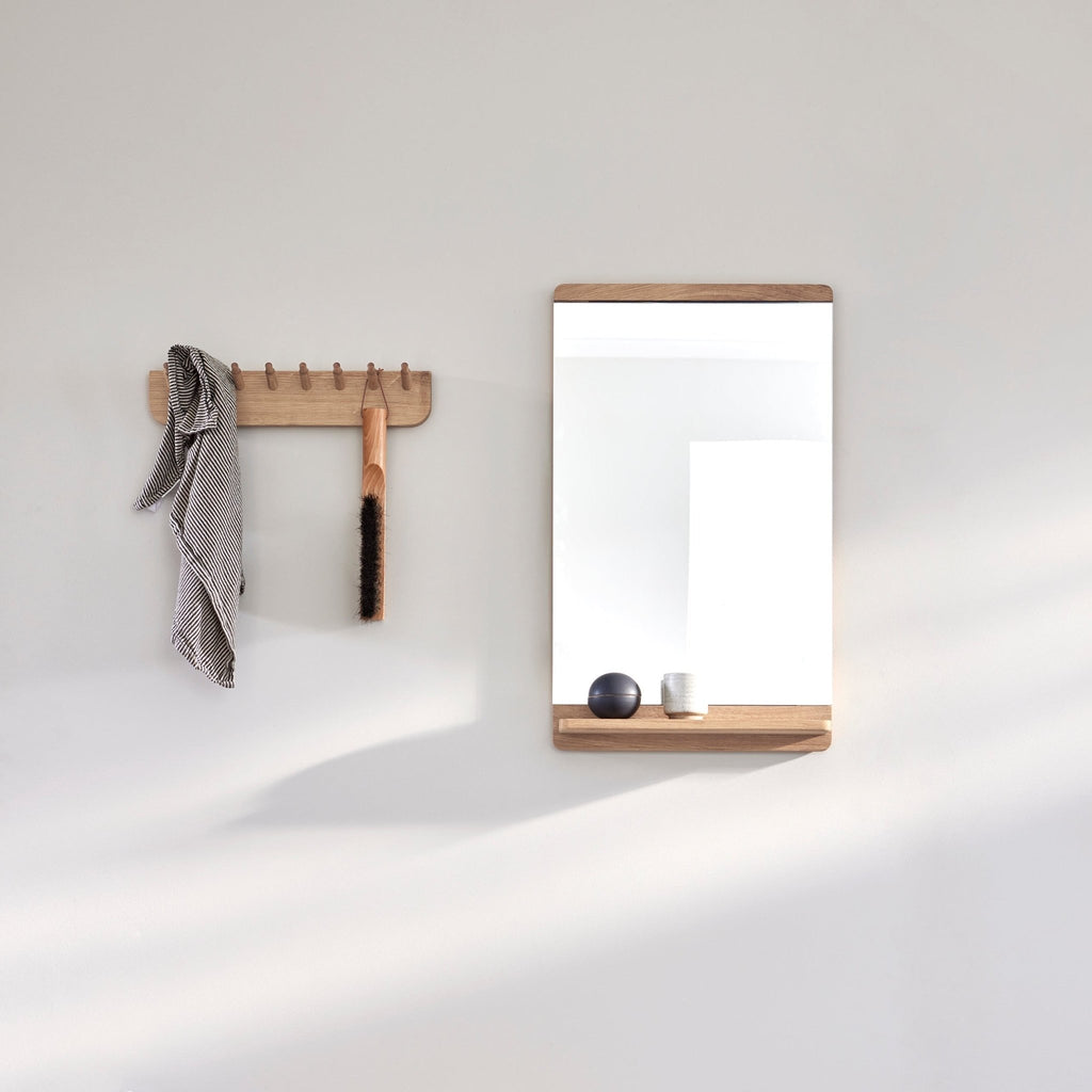 A FORM & REFINE RIM WALL MIRROR adorned with a towel hanging from its Gestalt Haus-inspired design.