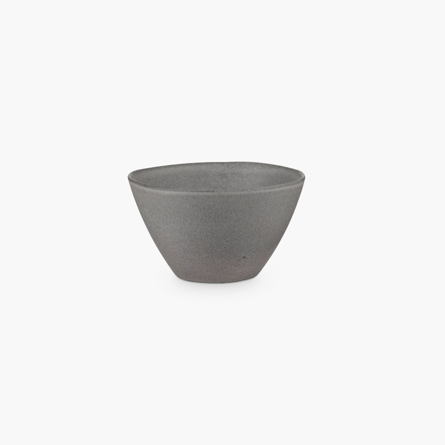 A small grey STUDIO TABLEWARE bowl on a black background by KLASSIK STUDIO at Gestalt Haus.