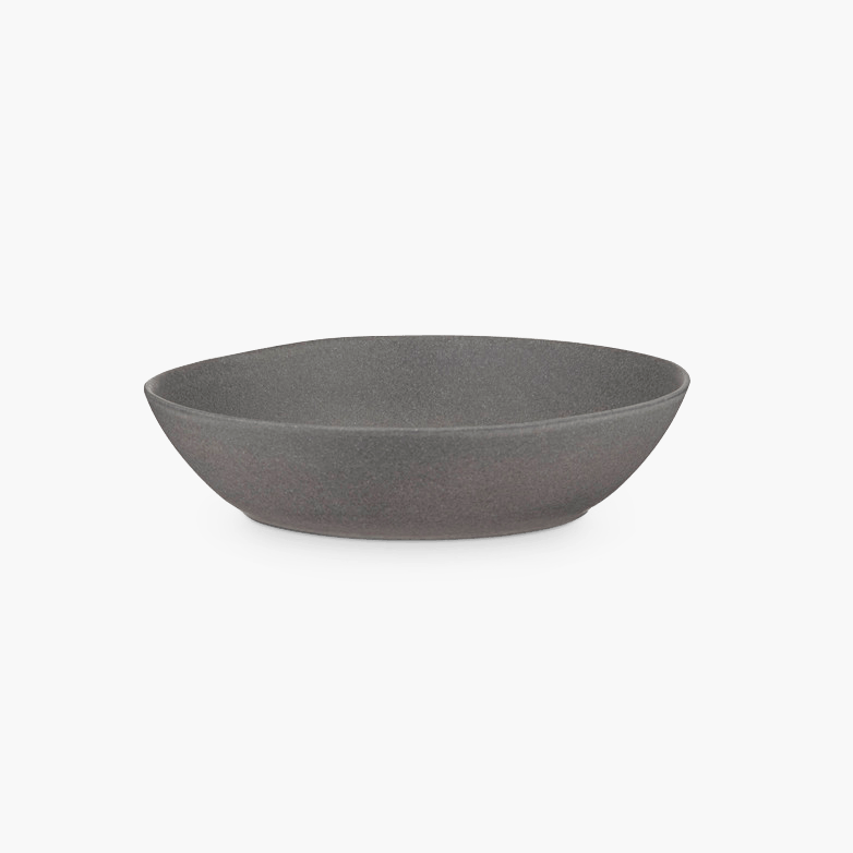 A STUDIO TABLEWARE grey bowl on a black background, designed by KLASSIK STUDIO in the style of Gestalt Haus.