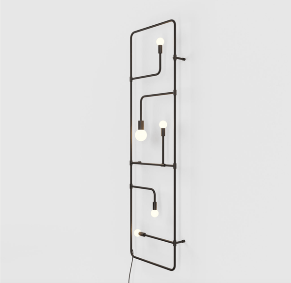 A metal wall light with three bulbs hanging from it, designed by Gestalt Haus: the Lambert et Fils Beaubien Lamp.