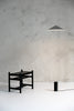 A black THE WISP LAMP with a stool next to it, designed by ANONY and inspired by Gestalt Haus.