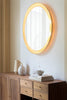 A ATBO Floris Wall Mirror, a round mirror designed by a Dutch designer, placed on top of a dresser.