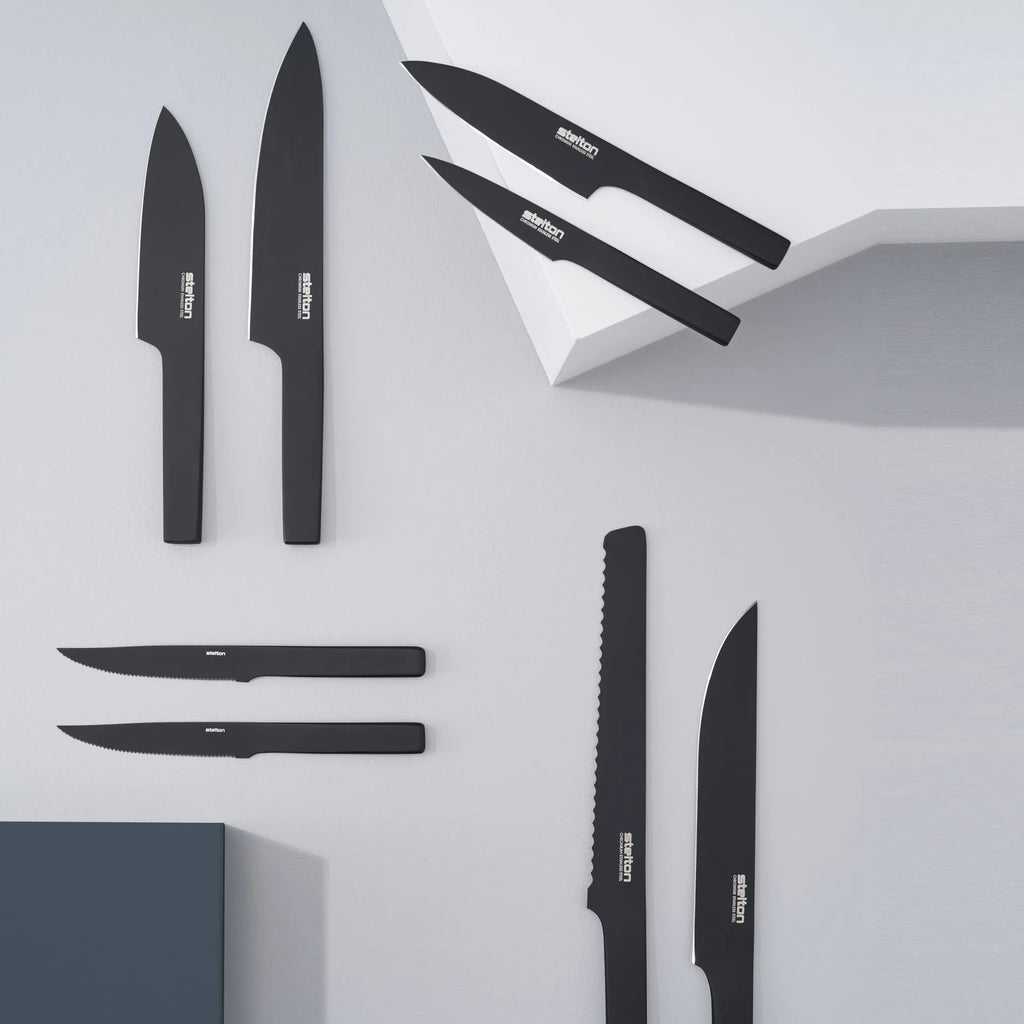 A set of STELTON PURE BLACK CARVING KNIVES on a white surface.