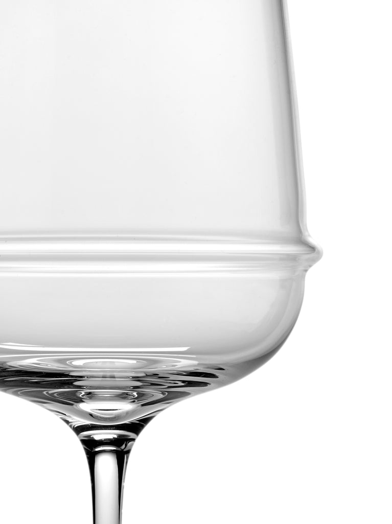 A clear Dune glassware by Kelly Wearstler with ribbed detailing on a white background.