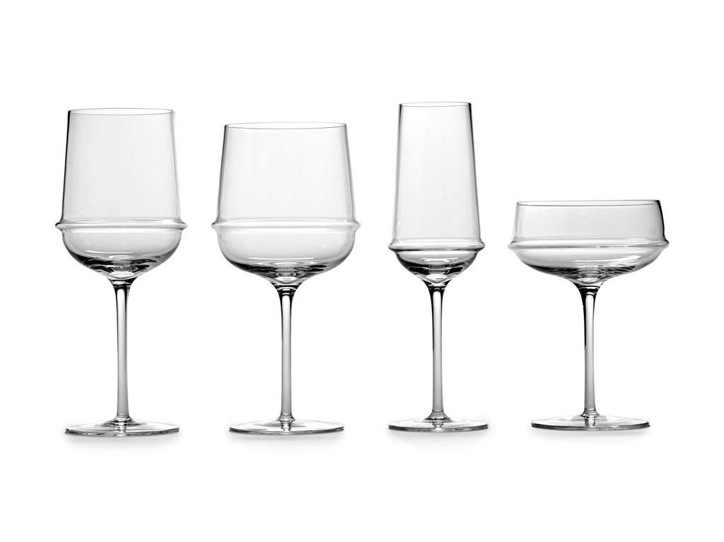 A set of four Dune glassware wine glasses by Kelly Wearstler on a white background.