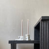 Two BRICK CANDLE HOLDERS made by 101 COPENHAGEN sit on a table next to a wall.