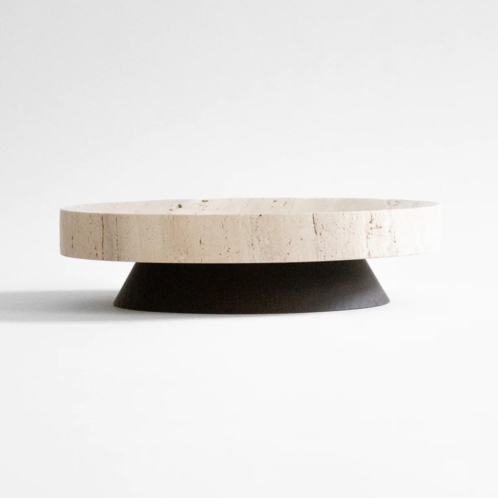 A round tray with a black base on a white surface, showcasing COLISEU PEDESTALS by ORIGIN MADE and its architectural heritage.