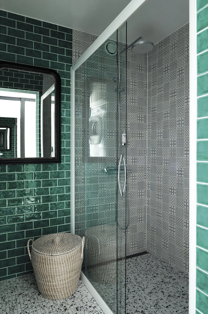A HAPPY HOMES CREATIVE bathroom with green tiled walls and a glass shower by COZY.