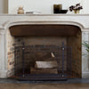 A fireplace with an ELDVARM Emma Firescreen and a basket on the side.