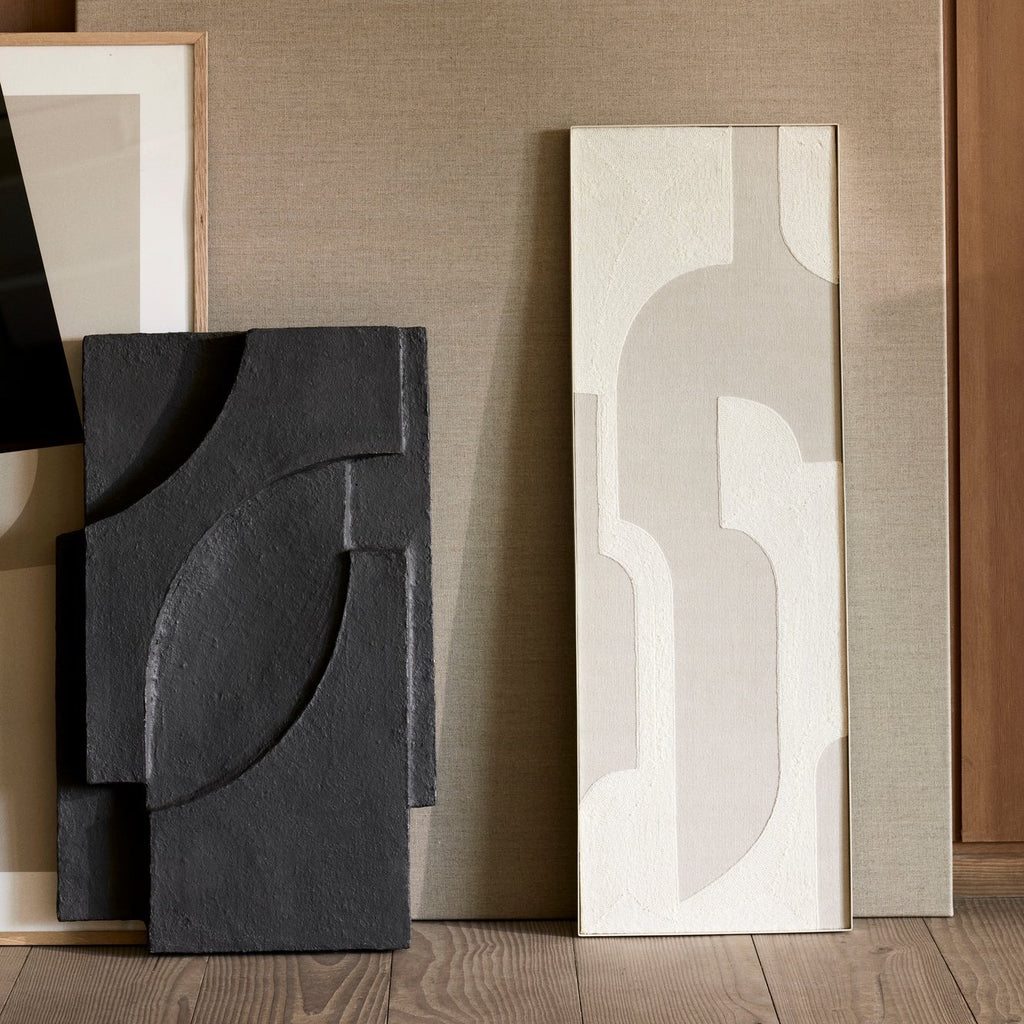 A group of SERIF RELIEF pieces of art on a wooden floor, showcasing the textured surfaces by KRISTINA DAM STUDIO.