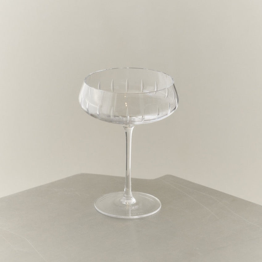 An exquisite Louise Roe Crystal Champagne Coupe showcasing impeccable craftsmanship, resting elegantly on a table.