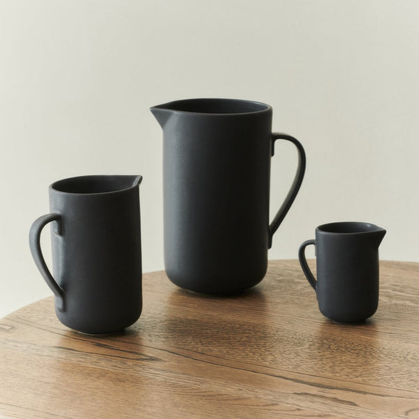 Handcrafted ceramics by Louise Roe, featuring three PISU PITCHER jugs on a wooden table.