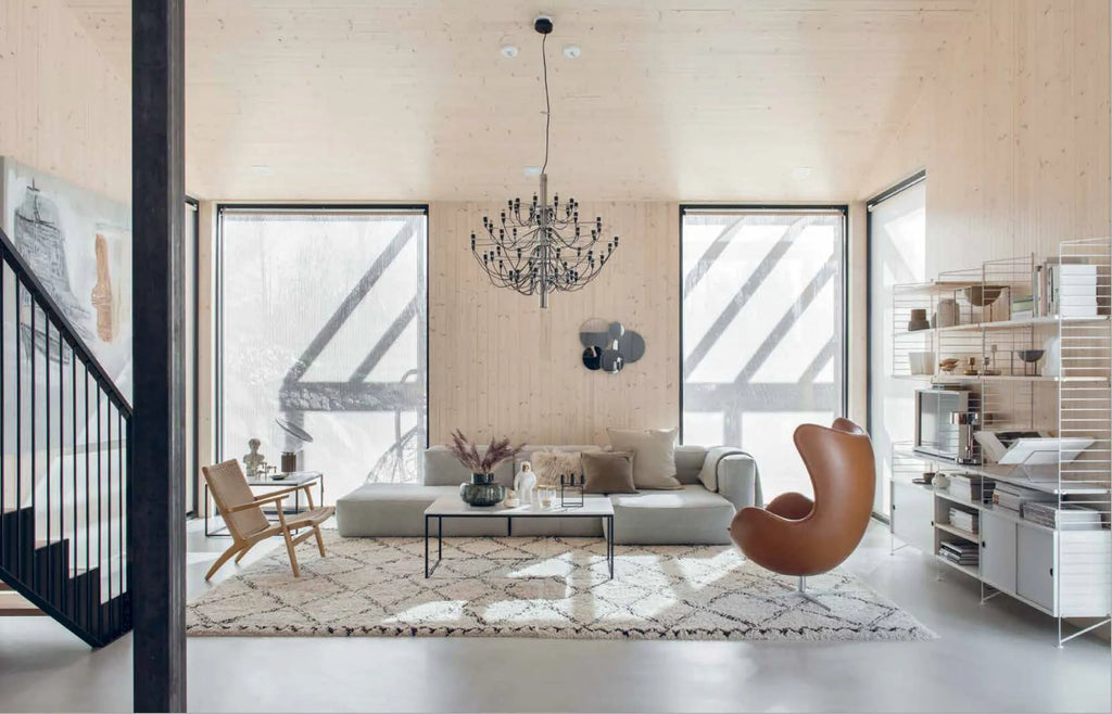 A living room with wooden floors and a COZY NORDIC INTERIOR BOOK chandelier.