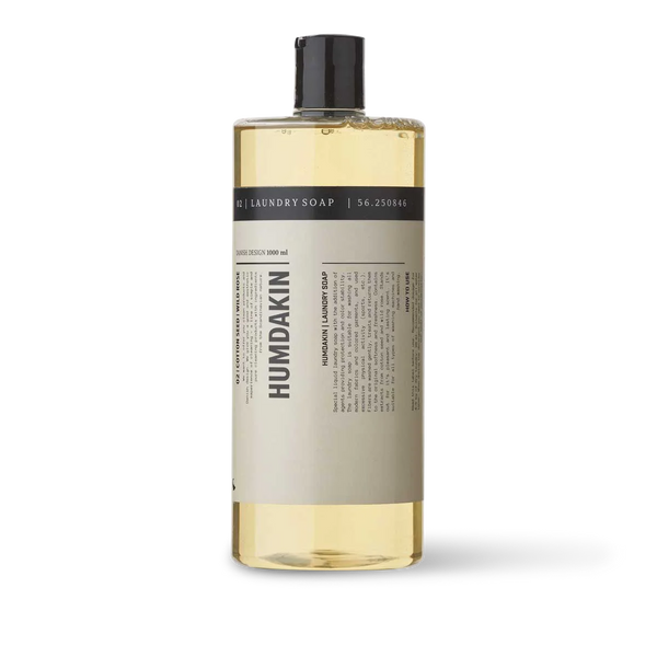 A bottle of 02 LAUNDRY SOAP COTTON SEED + WILD ROSE by HUMDAKIN with a black bottle on a white background infused with wild rose.