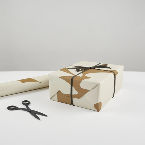 A pair of AEAND TULIP scissors and a gift wrapped in brown paper by KINSHIPPED.