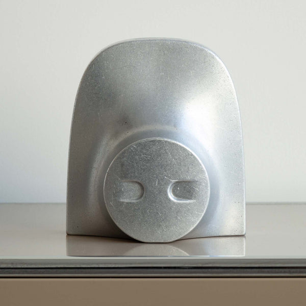 A piggy bank bookend from Studio Henry Wilson sits on top of a table.