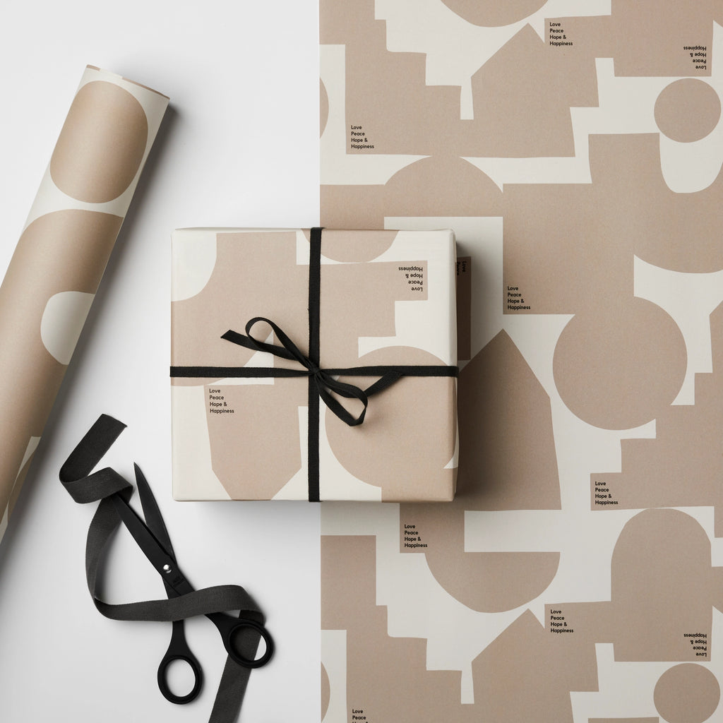 A Peace, Love, Hope & Happiness Gift Wrap by Kinshipped with geometric shapes and a pair of scissors.
