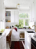 A kitchen with COZY white cabinets and a rug.